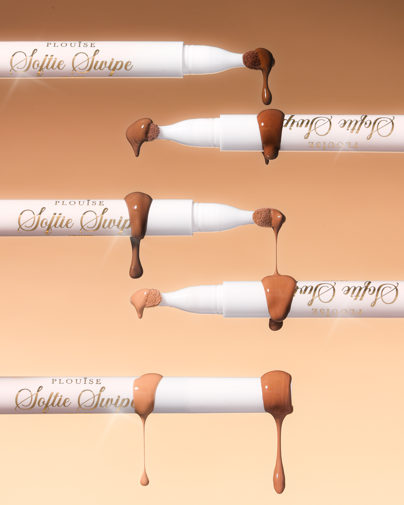 Kuva viidestä P.Louise Softie Swipe Swipe Tinted Lip Mask -naamiosta, joiden kärjestä tippuva tuote näyttää eri sävyt beigeä taustaa vasten