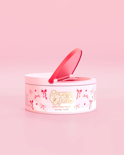 Vaaleanpunainen P.Louise Bright By Night Brightening Cream -tuote, jossa on punaisia ​​rusetin graafisia elementtejä vaaleanpunaista taustaa vasten