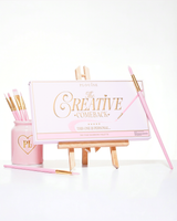 Suljettu vaaleanpunainen P.Louise Creative Comeback XXXL Rainbow Eyeshadow Palette asetettu taidetelineeseen, jota ympäröivät meikkisiveltimet