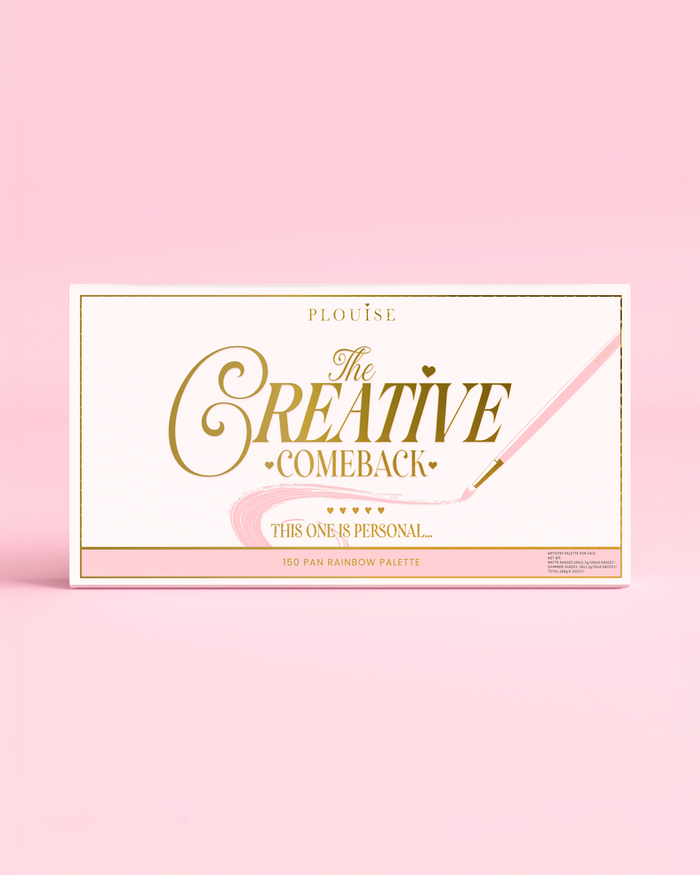Suljetun P.Louise Creative Comeback XXXL Rainbow Eyeshadow Paletin etupuoli kultaisella typografialla vaaleanpunaisessa kotelossa vaaleanpunaista taustaa vasten
