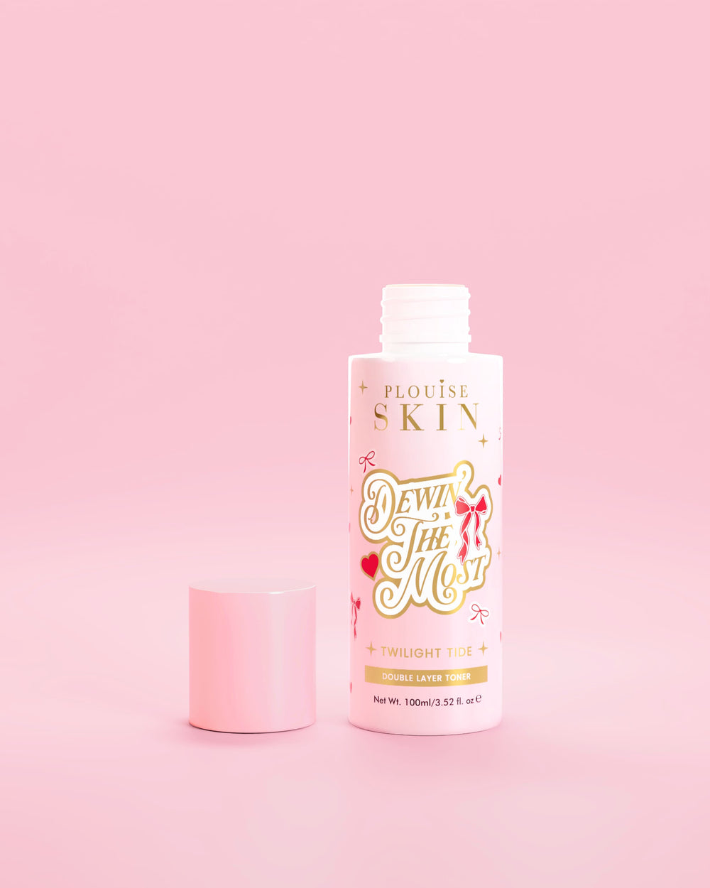 Vaaleanpunainen pullo P.Louise Dewinia MOst Double Layer Toner punaisella rusetilla vaaleanpunaista taustaa vasten 