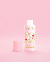 Vaaleanpunainen pullo P.Louise Dewinia MOst Double Layer Toner punaisella rusetilla vaaleanpunaista taustaa vasten 