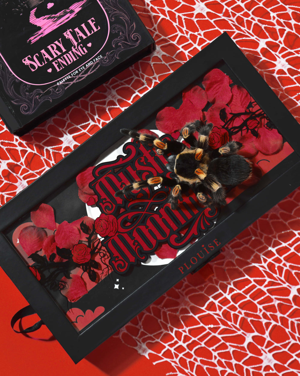 P.Louise Mystic Moonlight Halloween -luomiväripalettilaatikko peitetty punaisilla ruusun terälehdillä ja tarantulalla punaisella hämähäkinverkkotaustalla