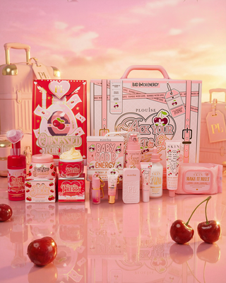 Collection of cherry blossom and cherry beauty products including the Pack Your Shit And Go bundle and the Obsessed For Less skincare bundles with a pink and red colour scheme on a reflective surface.