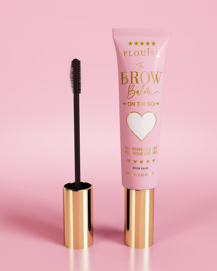 P.Louise Fluffy Soap Brow Balm Instant Fix -tuote vaaleanpunaisessa putkessa, jossa on kultainen korkki, mukana musta kulmakarvaharja vaaleanpunaista taustaa vasten.
