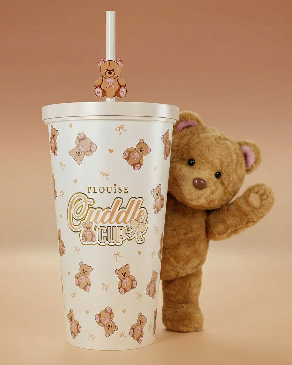 Kuva P.Louise Teddy Bear Steel Cuddle Cup -pullosta ja oljista, jonka takaa heiluttaa karhu