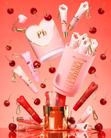 Pink XL Protect Your Pout -lahjasetti, joka avataan kirsikoiden ja vaaleanpunaisten ja punaisten huulihoitoaineiden ympäröimänä vaaleanpunaisella taustalla