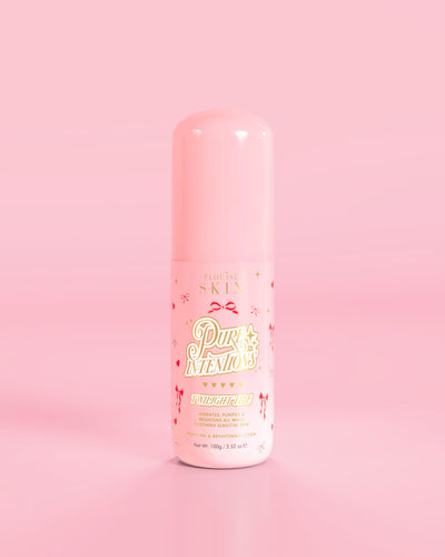 Vaaleanpunainen pullo P.Louise Pure Intentions Purify & Brightening Lotion -voidetta punaisella rusetilla vaaleanpunaista taustaa vasten