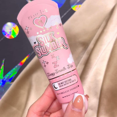 Henkilö pitelee P.Louise Silk Slumber Poreless Primer -pohjustuspohjaa, jossa on vaaleanpunainen tausta ja kosmeettisia tuotetietoja.